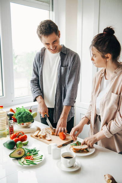 Mann und Frau amüsieren sich gemeinsam in der Küche beim Frühstücken. Gesundes Essen. Familienküche. Gesunde Ernährung. - Foto, Bild