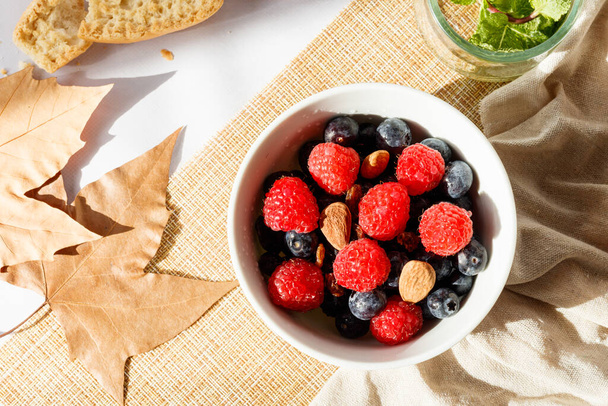 Сніданок в осінньому стилі з червоними фруктами, горіхами, медом, молоком і тостами
 - Фото, зображення