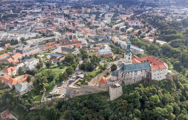 Luftbild von oben nach unten von Nitra Burg und Kirche mit rotem Schindeldach Bischofspalast in der Mittelslowakei auf einem Hügel mit großen Kanonenplattform Bastionen - Foto, Bild