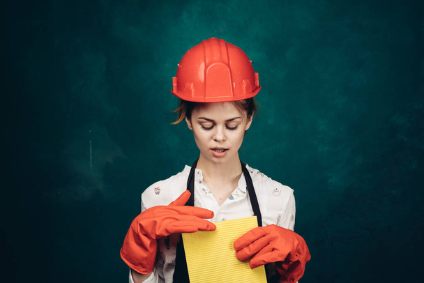 woman in black apron orange hard hat protection cleaning - Photo, image