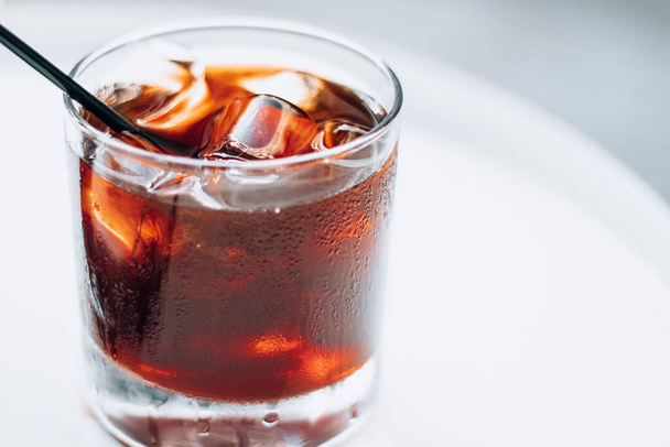 Cold brew with full of ice and black straw on a white background. Delicious cold beverage with coffee. - Photo, Image