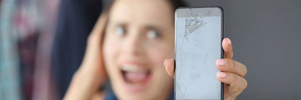Mulher perturbada segurando smartphone quebrado nas mãos - Foto, Imagem