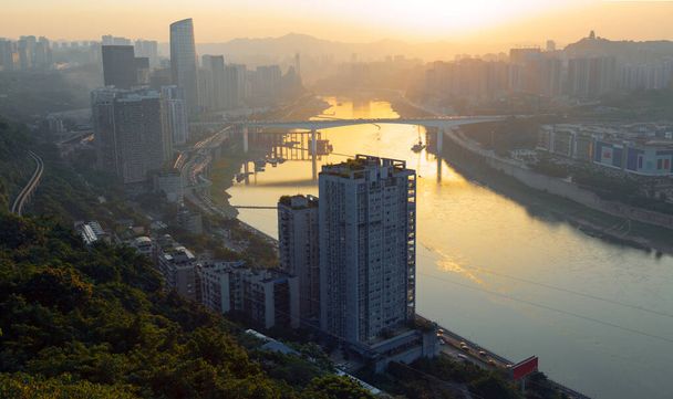 Chongqing jest miastem górskim. W Chongqing Goose Ridge Park, można zobaczyć rzekę płynącą przez miasto z daleka i krajobraz miasta na brzegach rzeki - Zdjęcie, obraz