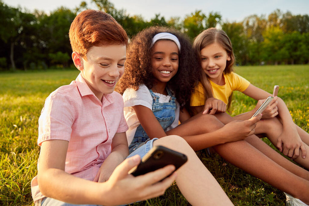 Diverse kids using smartphone together - Valokuva, kuva