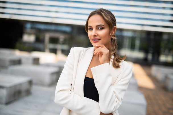 Smiling businesswoman posing outdoor near her office - Foto, afbeelding