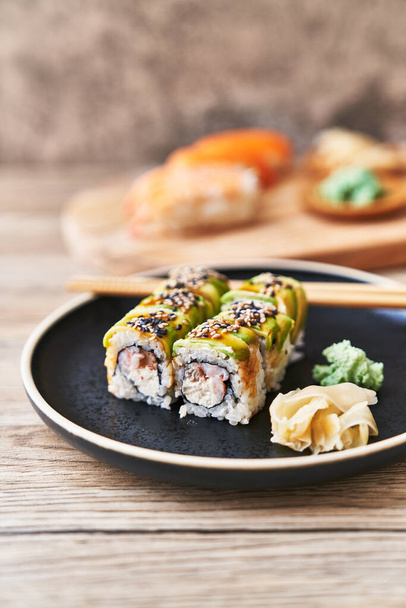  Plate of shrimp and cheese cream uramaki sushi on a wooden surface - Photo, Image