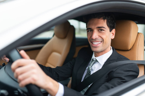 Handsome smiling man driving his car - 写真・画像