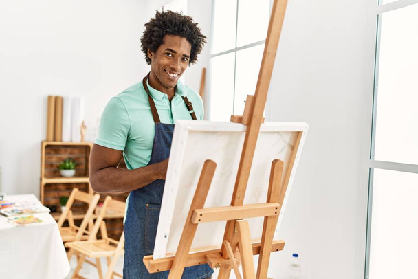Joven afroamericano artista hombre sonriendo feliz dibujo en el estudio de arte. - Foto, Imagen