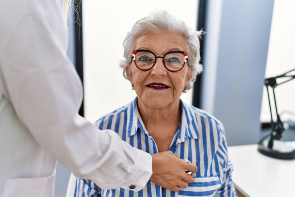 Patiente âgée aux cheveux gris ayant une consultation médicale auscultant le cœur à la clinique - Photo, image