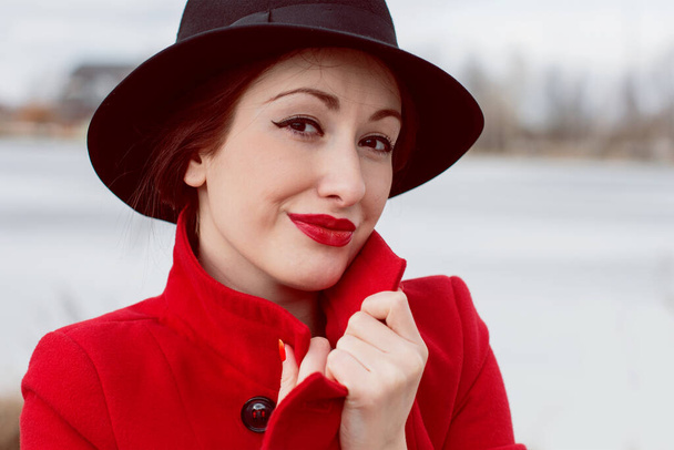 Beautiful French stylish woman in red coat walking in park - Photo, Image