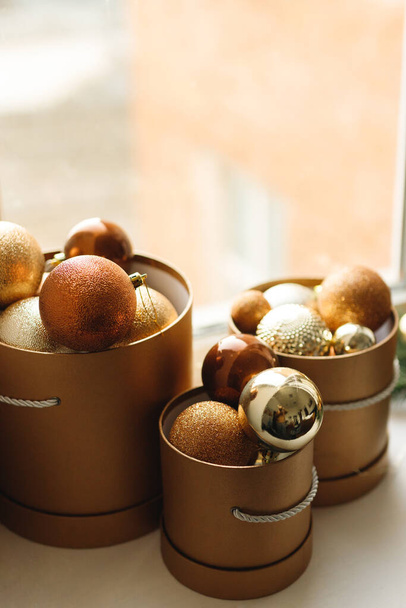 Close up of decorative Christmas brown balls in the gold box on a window - Foto, Imagen