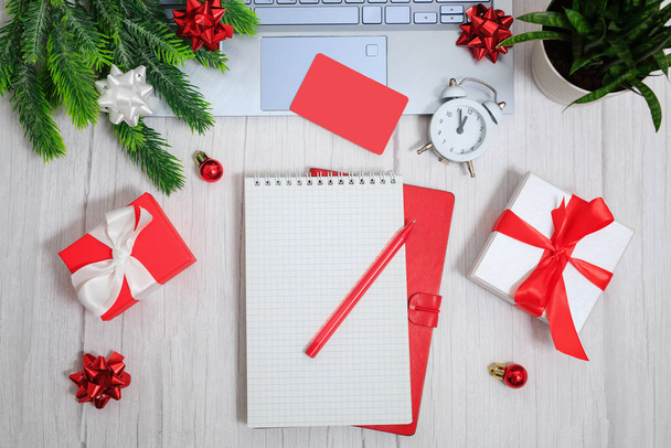 Christmas composition. Notepad with goals for 2022. Laptop, notebook, pen, gift boxes, alarm, balls and stars. Concept business Christmas. Goals and objectives - Photo, Image