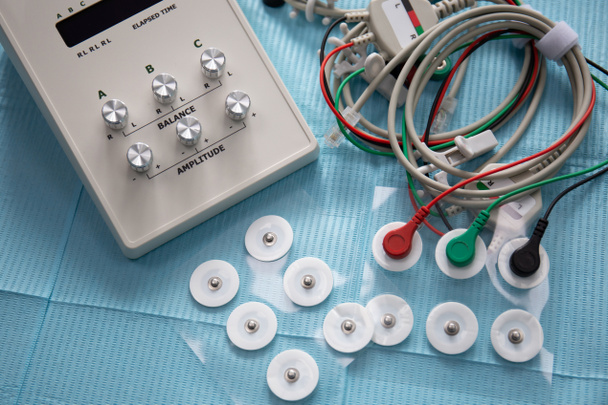 Dispositif de stimulation neuromusculaire de l'articulation temporomandibulaire avec fils et électrodes sur la table - Photo, image