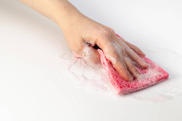hand houdt een zeepachtige washandje, op een witte achtergrond, concept, home cleaning, business, home hygiene, netheid - Foto, afbeelding
