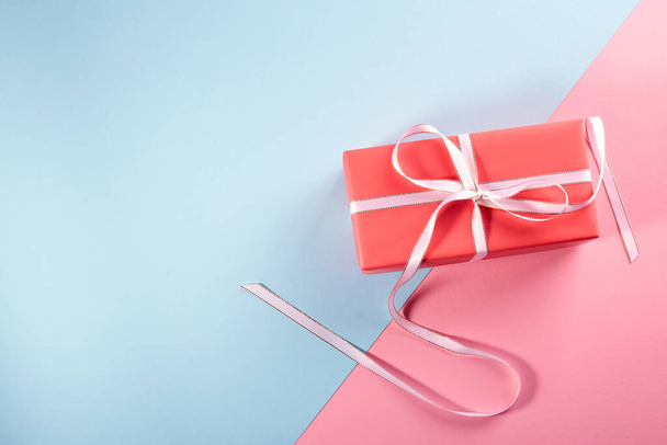 Gift in bright packaging. Pink-blue background - Photo, Image