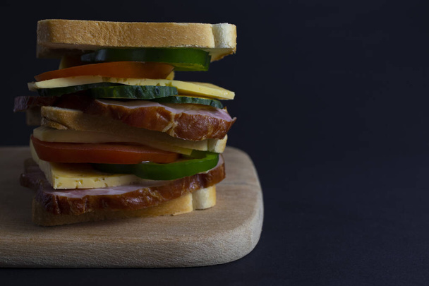 Sebzeli sandviç, esmer arka planda jambon ve peynir. Sandviç sosisi ve domates sebze burger jambon et porsiyonu açık büfe yemek üst görünüm fotokopi alanı metin yiyecekleri arka plan kırsal görüntü için - Fotoğraf, Görsel