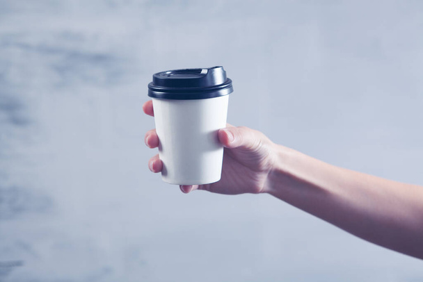 a female hand holds a disposable cup of coffee - Foto, immagini