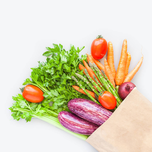 Φρέσκα βιολογικά λαχανικά σε eco craft χάρτινη τσάντα για ψώνια σε επίπεδο lay, top view με αντίγραφο χώρου σε γκρι φόντο. Βιώσιμος τρόπος ζωής Μηδέν απόβλητα, πλαστικό δωρεάν, πακέτο φροντίδας, ιδέα δωρεάς - Φωτογραφία, εικόνα