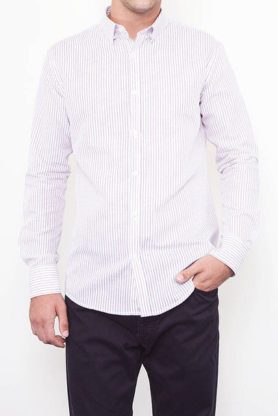 Handsome and confident young man wearing shirt while standing on white background.  - Valokuva, kuva