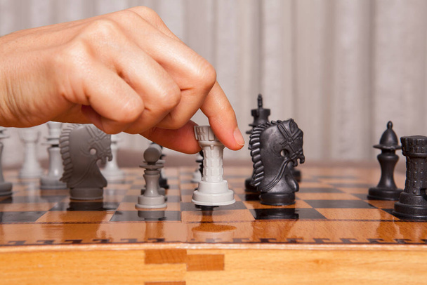 Γυναίκα που παίζει σκάκι κάνει την κίνησή του. Έννοια της επιχειρηματικής στρατηγικής και τακτικής. - Φωτογραφία, εικόνα