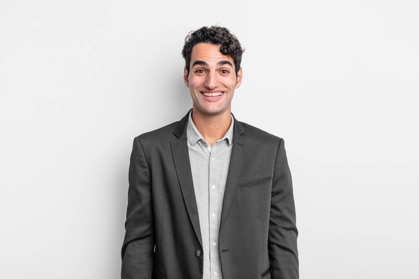 young businessman looking happy and pleasantly surprised, excited with a fascinated and shocked expression - Foto, afbeelding