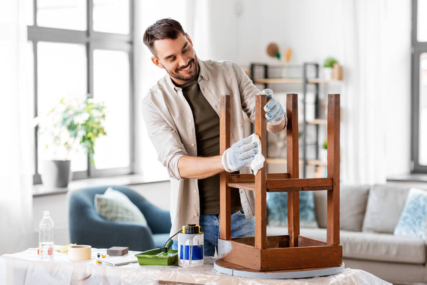 man cleaning old table surface with tissue - Fotoğraf, Görsel