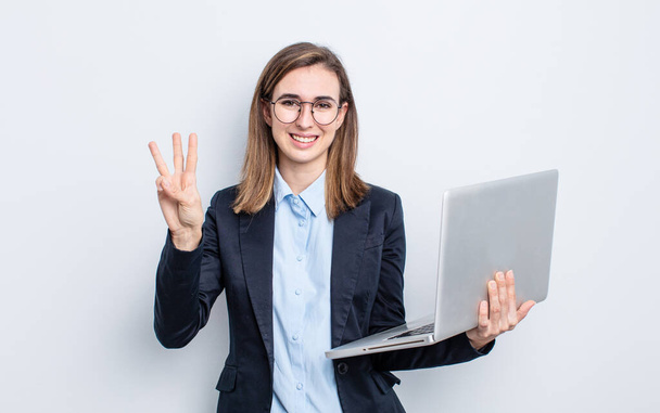 businesswoman young pretty woman smiling and looking friendly, showing number three. business and laptop concept - 写真・画像