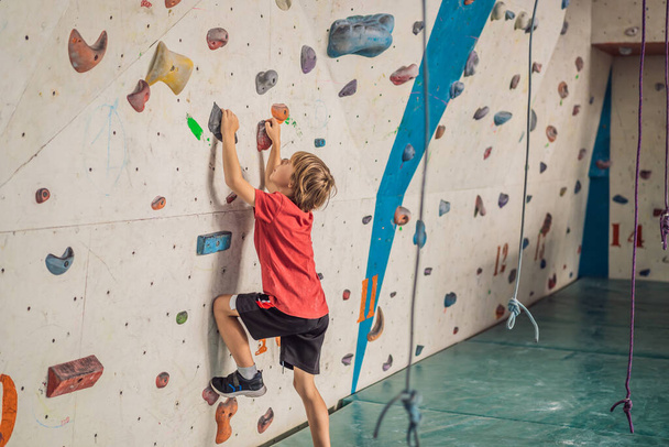 Boy at the climbing wall without a helmet, danger at the climbing wall - Φωτογραφία, εικόνα