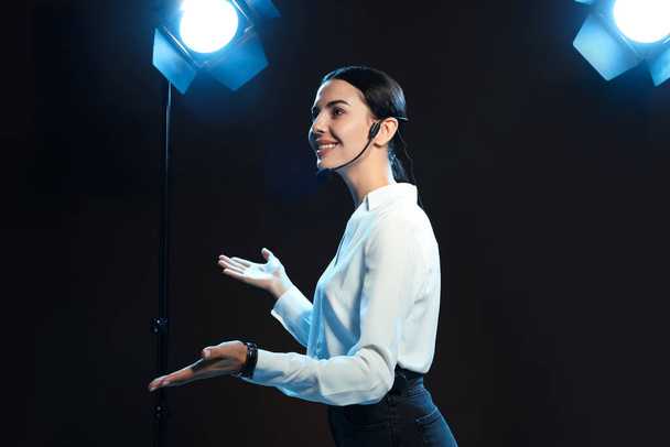 Motivational speaker with headset performing on stage - Valokuva, kuva
