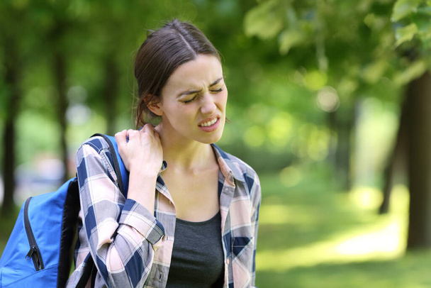 Stressed student complaining about neck ache walking in a park - Fotografie, Obrázek