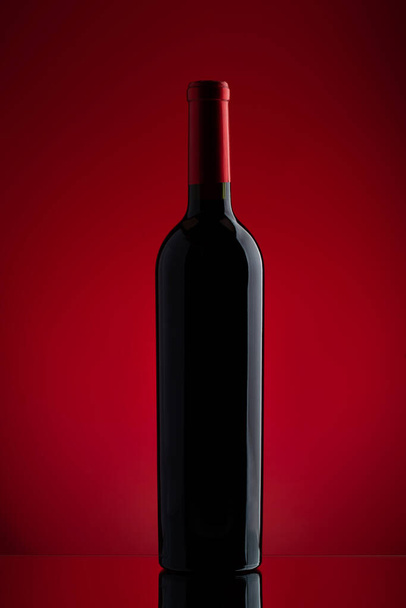Bottiglia di vino rosso su sfondo rosso - Foto, immagini