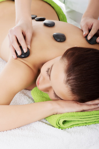 Girl on a stone therapy, hot stone massage - Foto, imagen