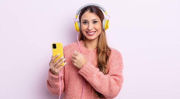 asiatic pretty woman feeling happy and facing a challenge or celebrating. headphones and phone concept - Fotoğraf, Görsel