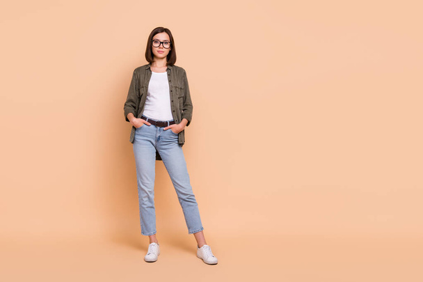 Photo of confident successful business lady hands pockets wear specs khaki shirt jeans isolated beige color background - Fotografie, Obrázek