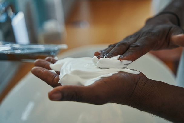 Male applying layer of foam on palm of his hand - Fotoğraf, Görsel