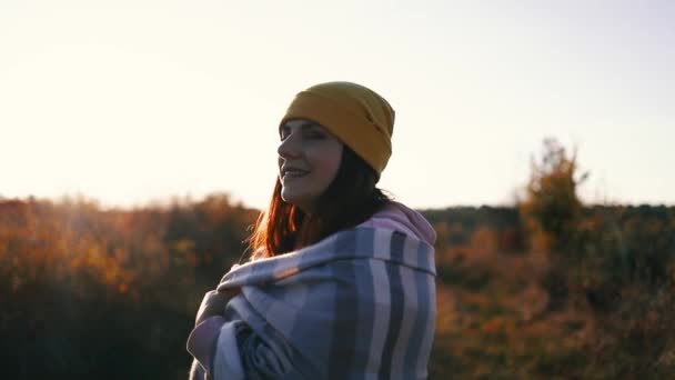Atractiva hembra relajándose en la naturaleza. Feliz mujer libre con sombrero amarillo y ropa acogedora con bufanda de cachemira divertirse al aire libre en el parque de otoño - Metraje, vídeo