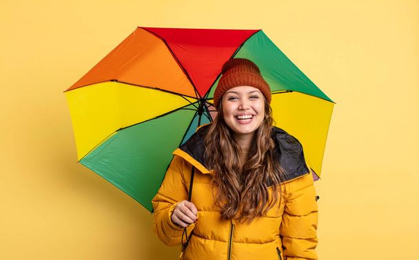 hispanic pretty woman looking happy and pleasantly surprised. umbrella concept - Foto, afbeelding