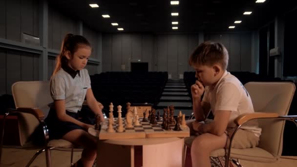 Schachspiel zweier Kinder in einem großen Konzertsaal - Filmmaterial, Video
