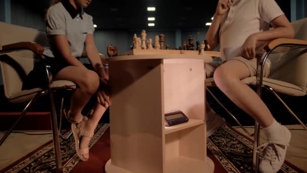 Νεαρό αγόρι πιέζει χρονόμετρο σκάκι κατά τη διάρκεια τουρνουά σκάκι εναντίον συμμαθητή - Πλάνα, βίντεο