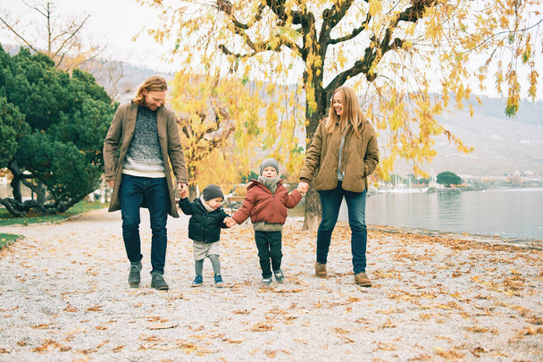 Dört çocuklu mutlu bir ailenin açık hava portresi, anne ve baba göl kenarındaki sonbahar parkında çocuklarla oynuyor, soğuk hava. - Fotoğraf, Görsel