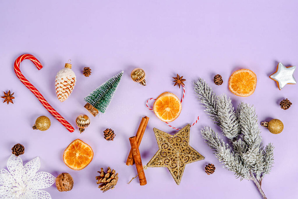 Festive composition on a purple background with Christmas decorations and toys for the Christmas tree - Foto, Imagen