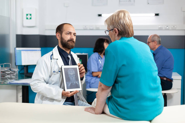 Arzt hält Tablette mit Röntgenbild für Osteopathie-Diagnose - Foto, Bild