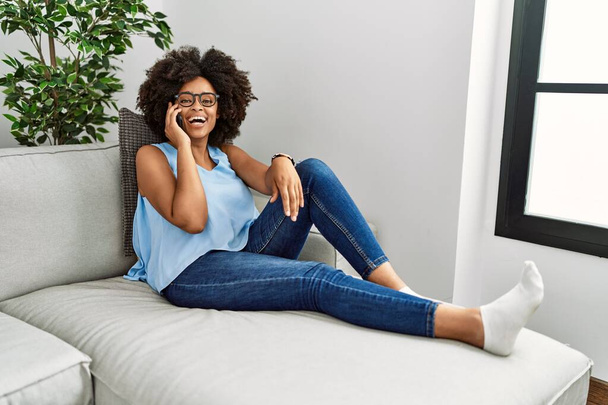 Young african american woman smiling confident talking on the smartphone at home - Photo, image