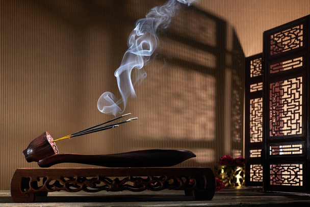 Smoke from burning incense sticks standing on lotus incense holder - Photo, Image
