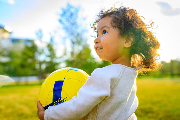 afro american little girl with curly hair playing ball outdoors - Foto, afbeelding