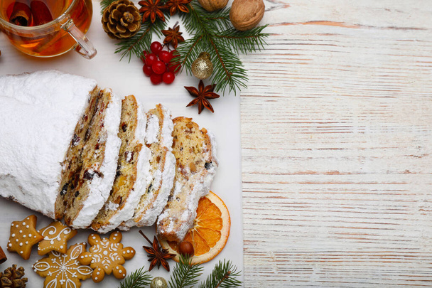 Traditional Christmas Stollen with icing sugar on white wooden table, flat lay. Space for text - Foto, Bild
