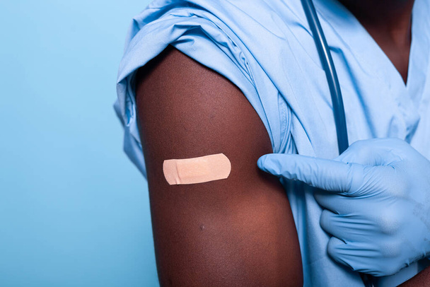 看護師の腕に撃たれた包帯されたワクチンの終わり - 写真・画像
