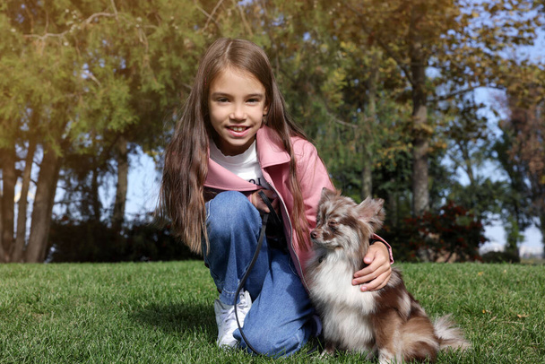 Little girl with her cute dog in park. Autumn walk - Photo, Image