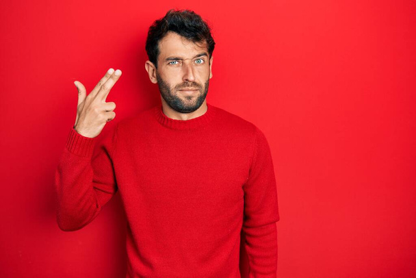 Handsome man with beard wearing casual red sweater shooting and killing oneself pointing hand and fingers to head like gun, suicide gesture.  - Foto, Bild