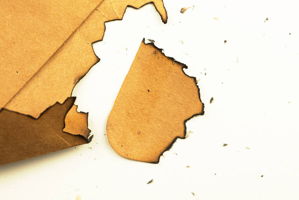 Burnt peice of old paper on a white background. Vintage and retro design - Foto, imagen